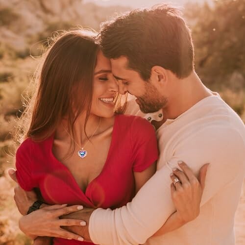 Smiling couple embracing outdoors in sunlight.