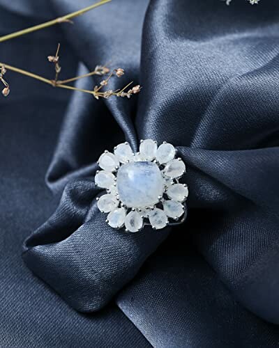 Elegant floral gem ring on dark fabric
