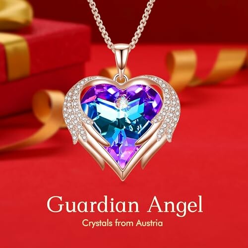 Heart-shaped crystal necklace with wings on a red background.